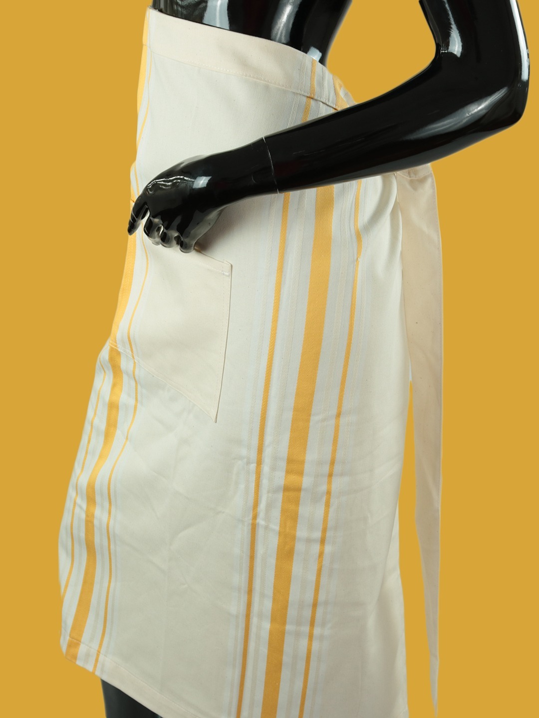 Avental de cozinha curto com riscas amarelas fabricado com algodão cru reciclado.